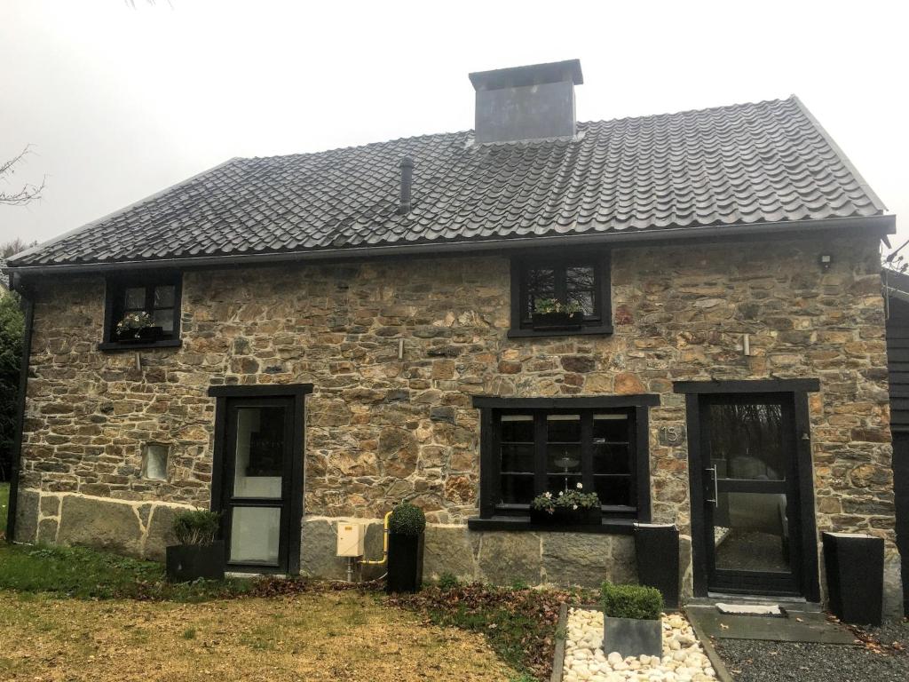 a stone house with black windows and a gray roof at Stylish Stay with Pool, Jalhay in Jalhay