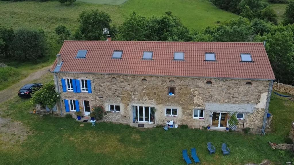 une ancienne maison en pierre avec un toit rouge dans l'établissement Gîte du Feuil, à Blassac