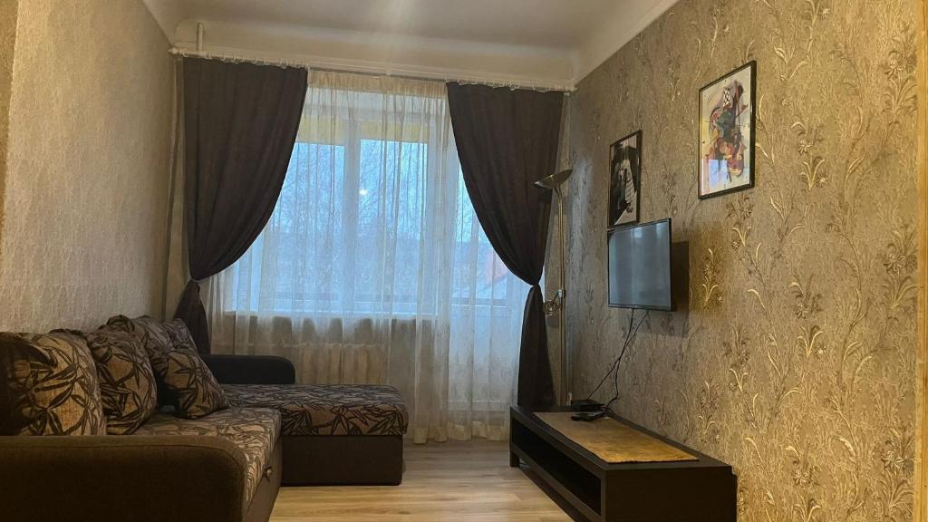 een woonkamer met een bank en een raam bij Imantas in Daugavpils