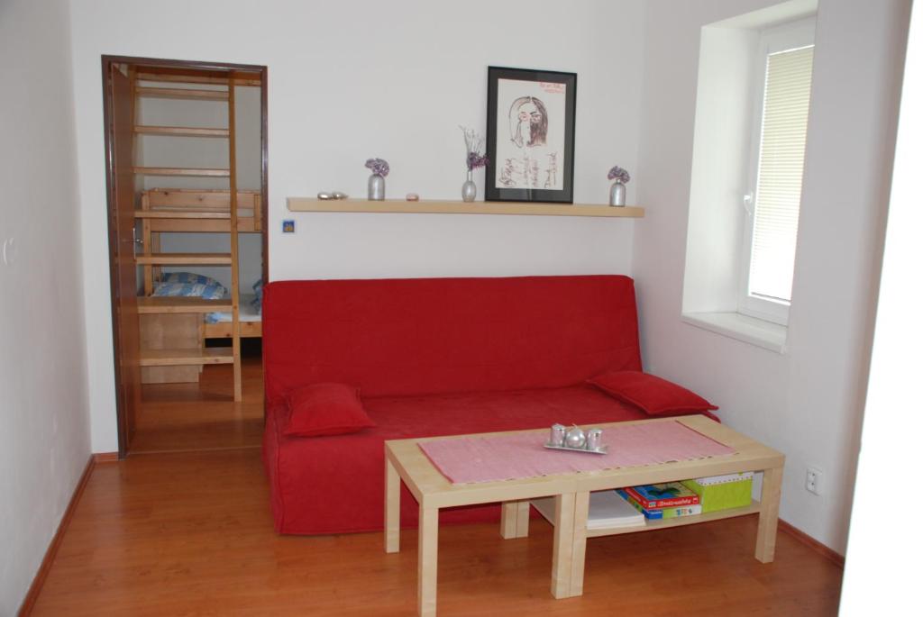 a living room with a red couch and a table at Apartmán Jeseník in Jeseník