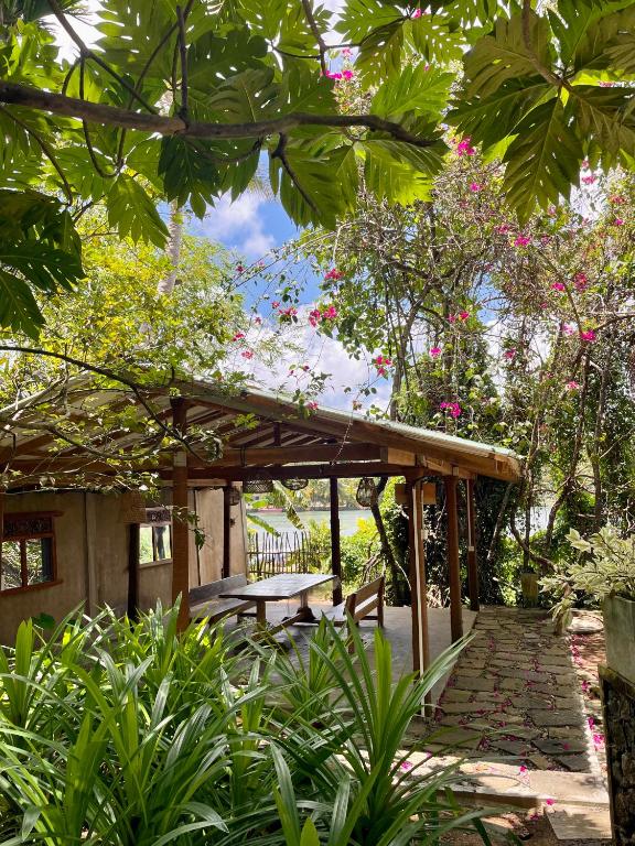 a pavilion with a picnic table in a garden at LAKE LOFT - La maison VEDA in Koggala