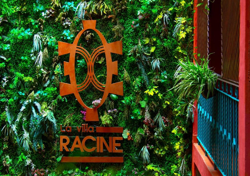 a green wall with a sign that reads to wild radio at Hôtel La Villa Racine in Dakar