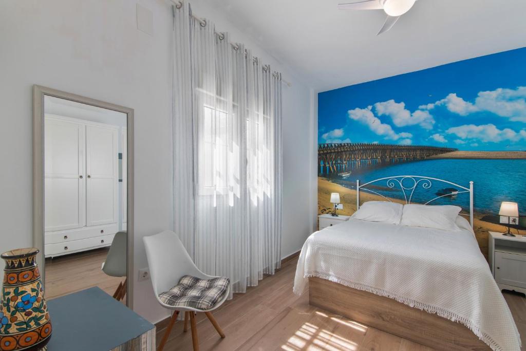 a bedroom with a bed and a painting on the wall at Casa Alma in Isla Cristina