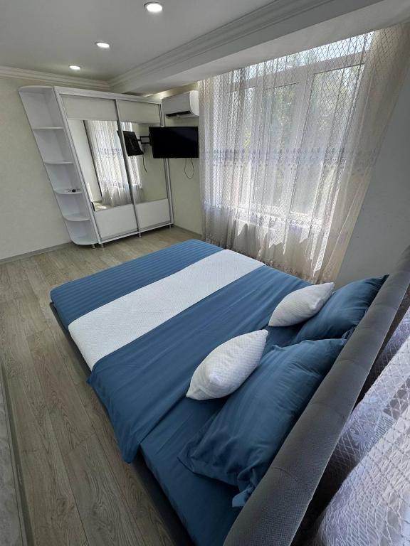 a bedroom with a large bed with blue sheets and pillows at Panorama view apartament tolstoi str in Chişinău