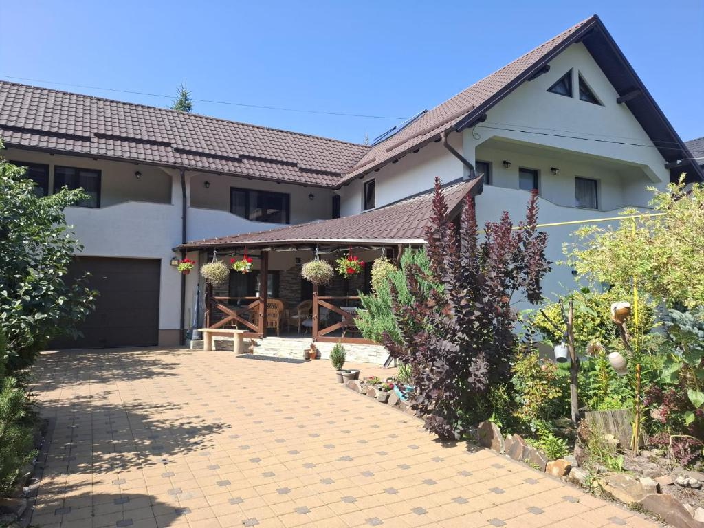 a house with a brick driveway in front of it at Casa de vacanta Sabrina in Gura Humorului
