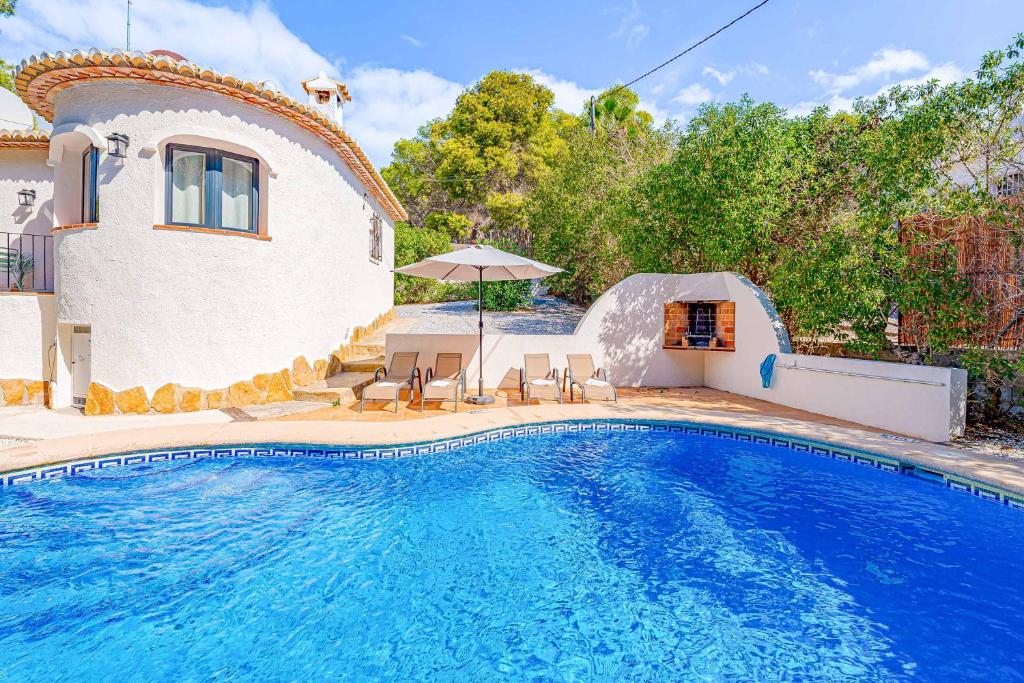 a swimming pool in front of a house at Villa Abeto in El Tosalet