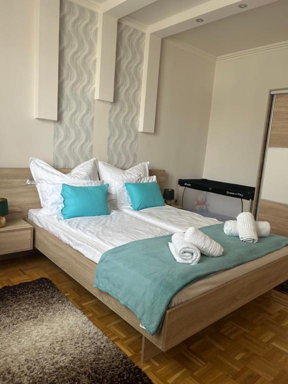 a bedroom with a large bed with blue pillows at László Apartman in Debrecen
