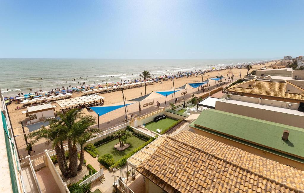 a view of a beach with umbrellas and the ocean at Stunning Apartment In Guardamar Del Segura in El Moncayo