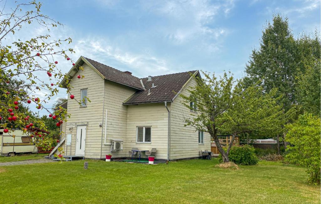 a white house with a yard with a tree at 2 Bedroom Stunning Apartment In Bodafors in Bodafors
