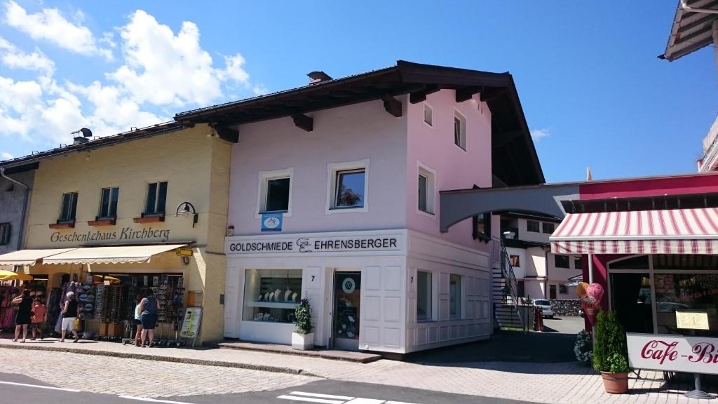 ein großes weißes Gebäude in einer Straße mit Geschäften in der Unterkunft Easy Home Johanna - Central Kirchberg in Kirchberg in Tirol