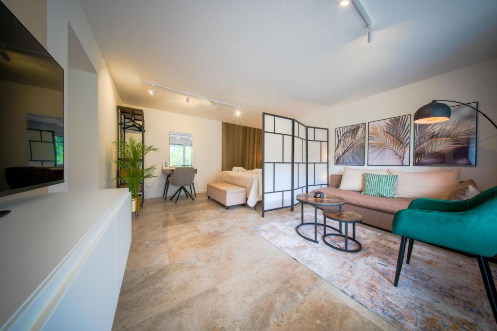 ein Wohnzimmer mit Sofa und Tisch in der Unterkunft Kurpark Apartment, Schwimmbad, Sauna, Terrasse in Bad Wildbad