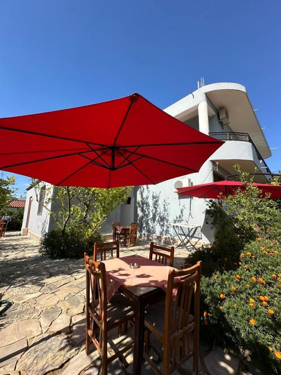 a table and chairs with a red umbrella at Guesthouse SELI in Berat