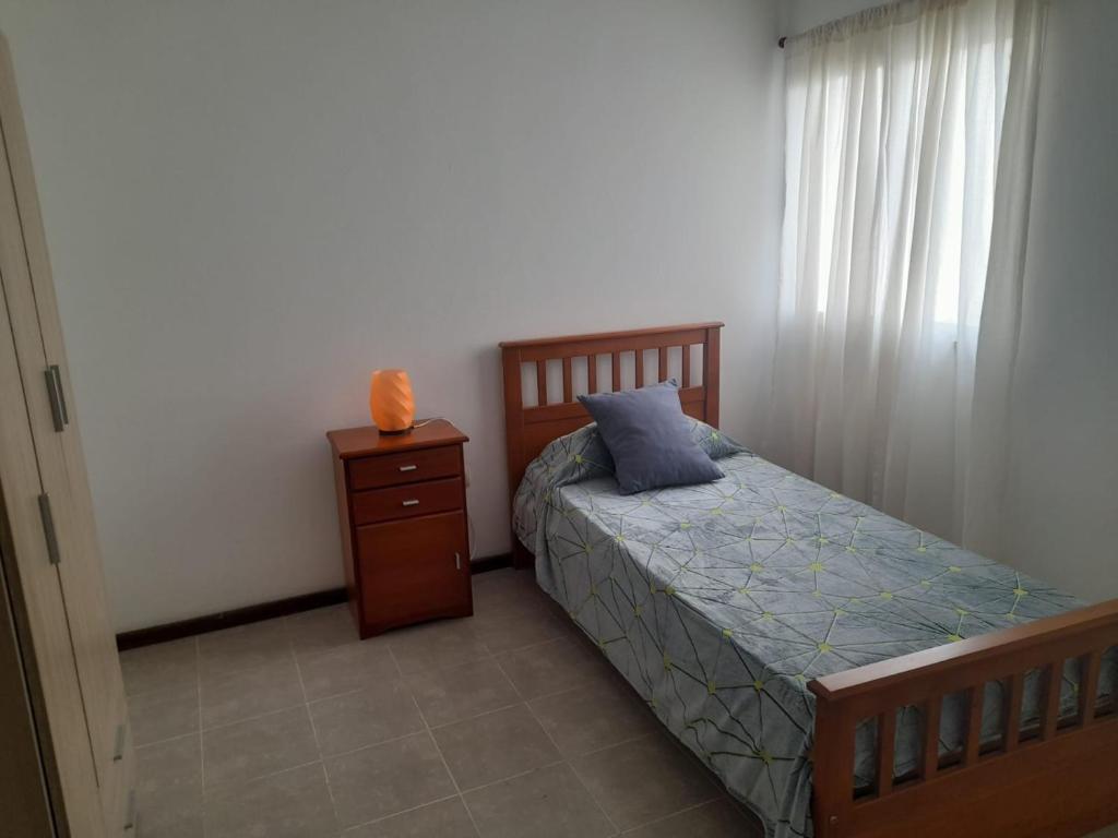 een slaapkamer met een bed, een ladekast en een raam bij Complejo Vélez Sarsfield 185 in Bell Ville