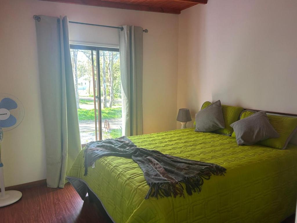 ベジャ・ビスタにあるCabaña San Jorgeのベッドルーム1室(緑色のベッド1台、窓付)