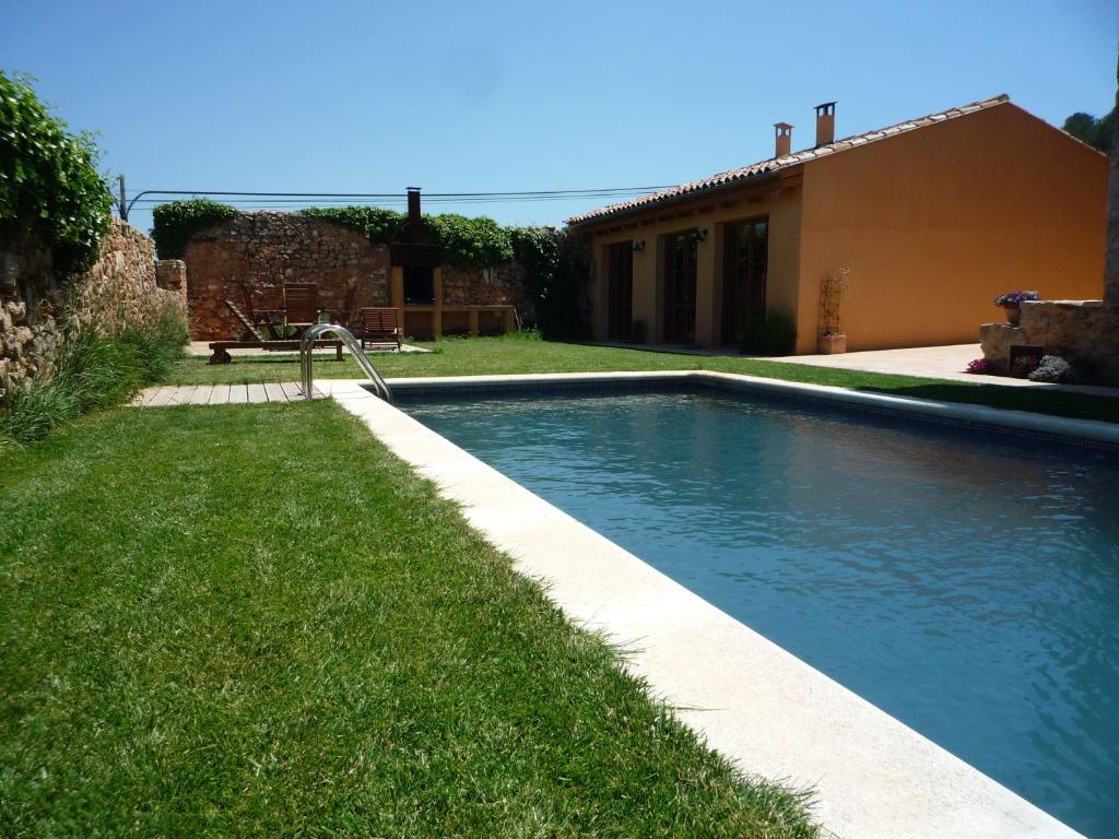 ein Schwimmbad in einem Hof neben einem Haus in der Unterkunft Can Gramunt in La Torre de Claramunt