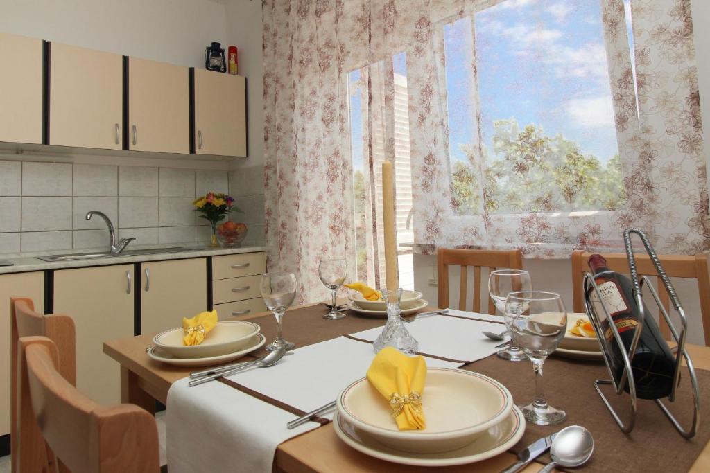 a kitchen with a table with chairs and a dining room at Apartments Nikolic in Šilo
