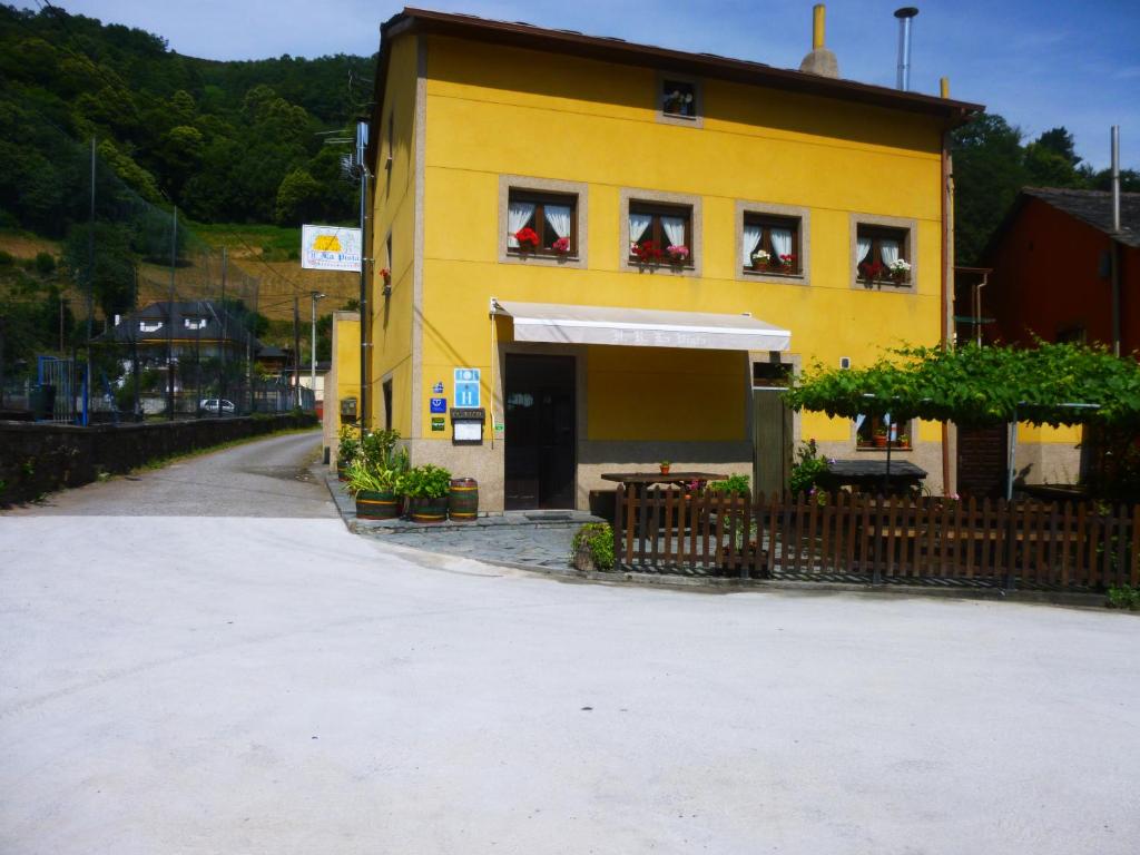 un edificio amarillo con gente sentada en las ventanas en Hotel Rural La Pista en Vega de Rengos