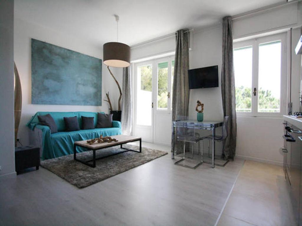 Rentopolis Fronte Mare Taggia في أرما دي تاجيا: غرفة معيشة مع أريكة زرقاء وطاولة