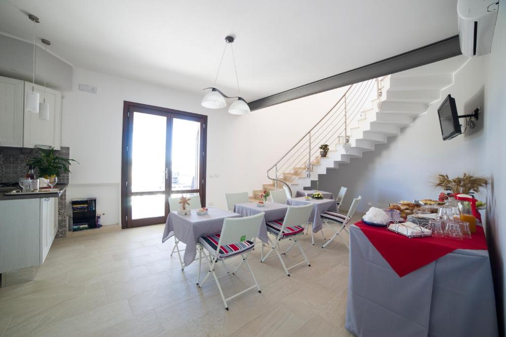 a dining room with tables and chairs and a staircase at Raggio Di Sale in Trapani