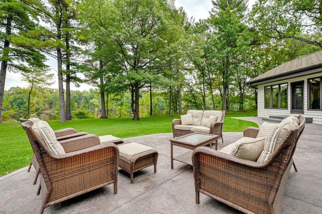 une terrasse avec des chaises et des tables en osier ainsi qu'une maison dans l'établissement Wisconsin River Gem 12 Mi to Granite Peak Ski Area, à Mosinee