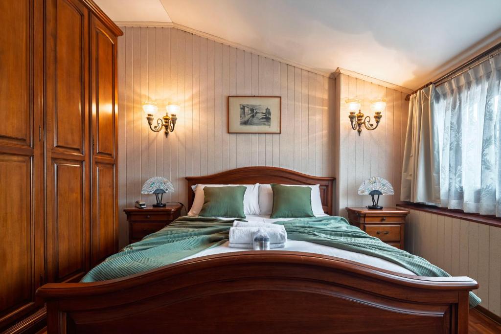 a bedroom with a large bed with green sheets at San Mauro Prestige House - Burano Island in Venice