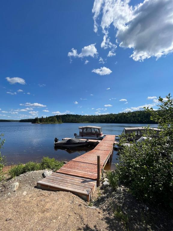 a dock with a boat on a lake at Chalet Lac Édouard cozy in La Tuque