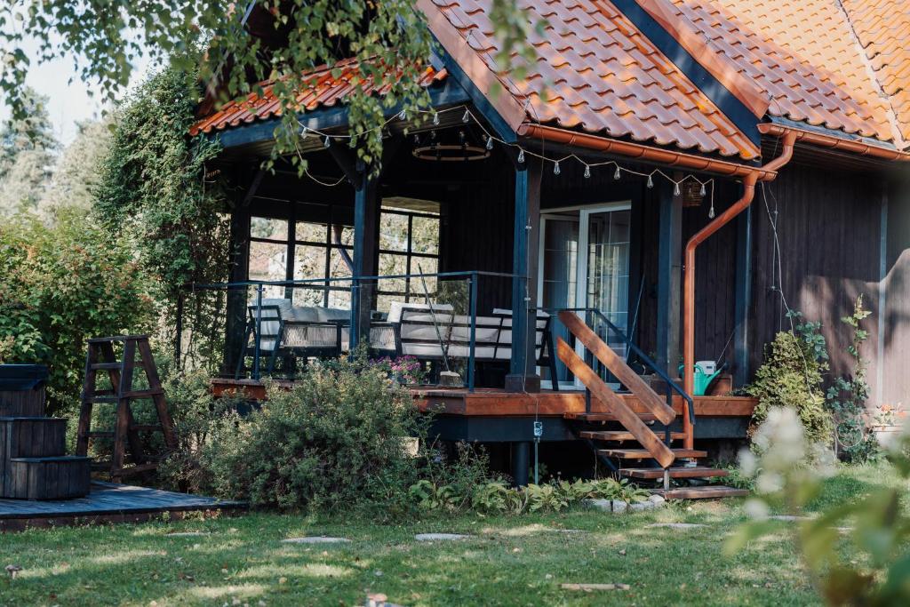 Gajówka في ايستينبا: منزل عليه شرفة وكراسي