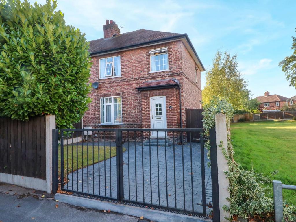 a brick house with a black iron fence at Ash House in Broadheath