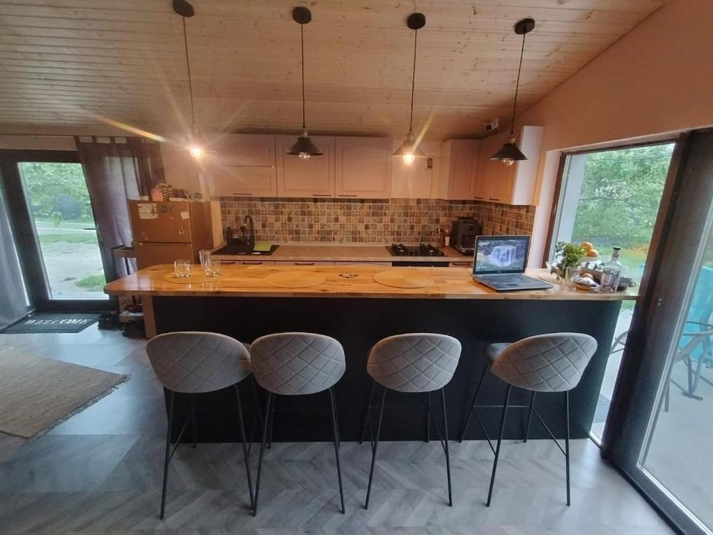 eine Küche mit einer Insel mit Barhockern und einem Laptop in der Unterkunft Casuta din Livada 2 