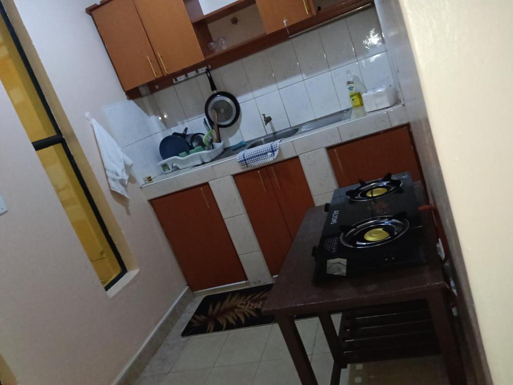 een kleine keuken met een tafel en een fornuis bij Lakesong Haven BNB, Naivasha, Kenya in Naivasha