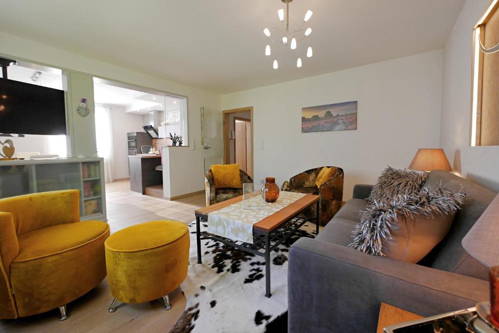 a living room with a couch and a table at Upland-Flair Ferienwohnung WALDPFAD im Zentrum! in Willingen