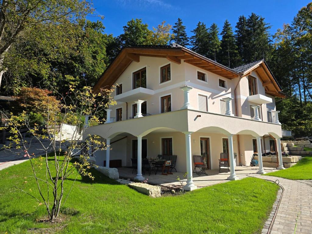 a large white house on a green lawn at Ferienwohnung am Eichberg in Winkl bei Grabenstätt