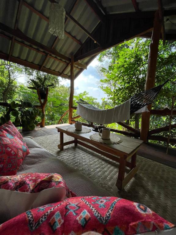 a patio with a hammock and a table with pots at Forest Retreat House Hammock & Private Terrace in Ban Nok