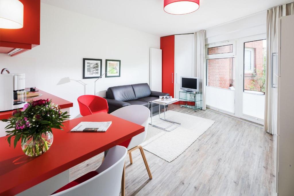 a living room with a red table and chairs at Appartementhaus Bracht - Kleine Welle in Juist