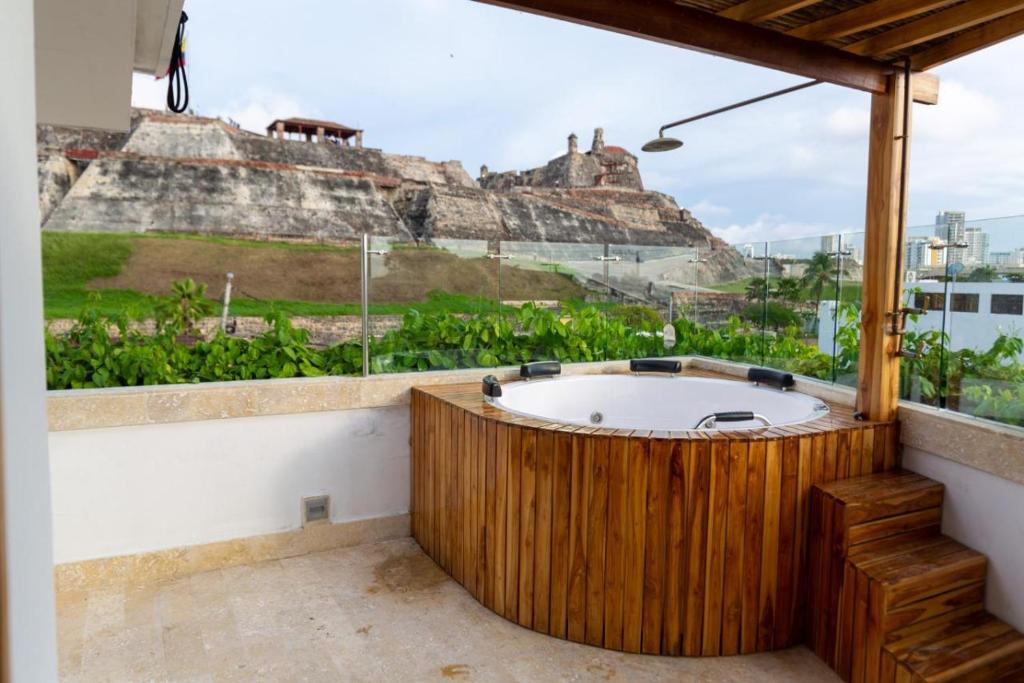 een bad in een kamer met uitzicht op een berg bij Blue House Castillo View Private Jacuzzi & Colonial Balconies in Cartagena