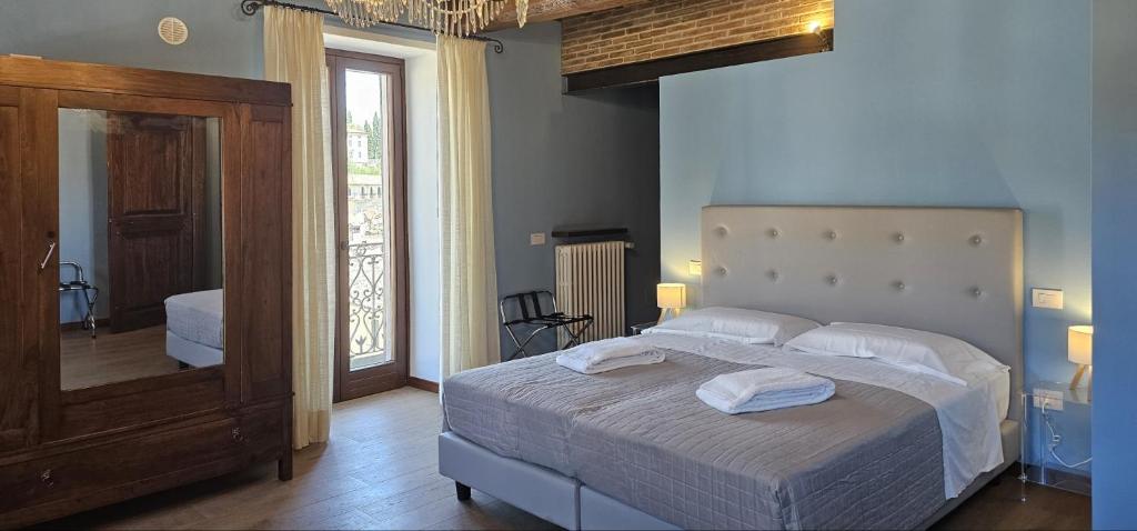 Un dormitorio con una cama grande y un espejo. en Palazzo Poggini, en Anghiari