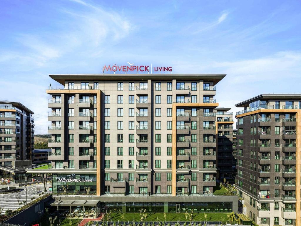 un grand bâtiment avec une enseigne au sommet dans l'établissement Movenpick Living Istanbul Camlivadi, à Istanbul