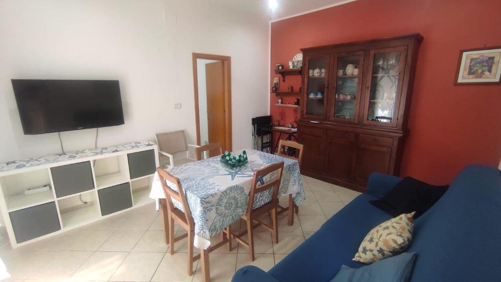 ein Wohnzimmer mit einem Tisch und einem blauen Sofa in der Unterkunft La Casa del Ferroviere in Letojanni