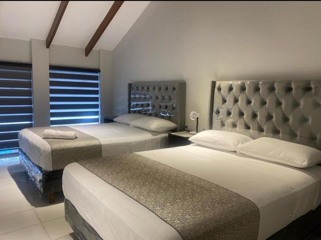 une chambre avec deux lits et une fenêtre dans l'établissement Hostal independencia, à Santa Cruz de la Sierra