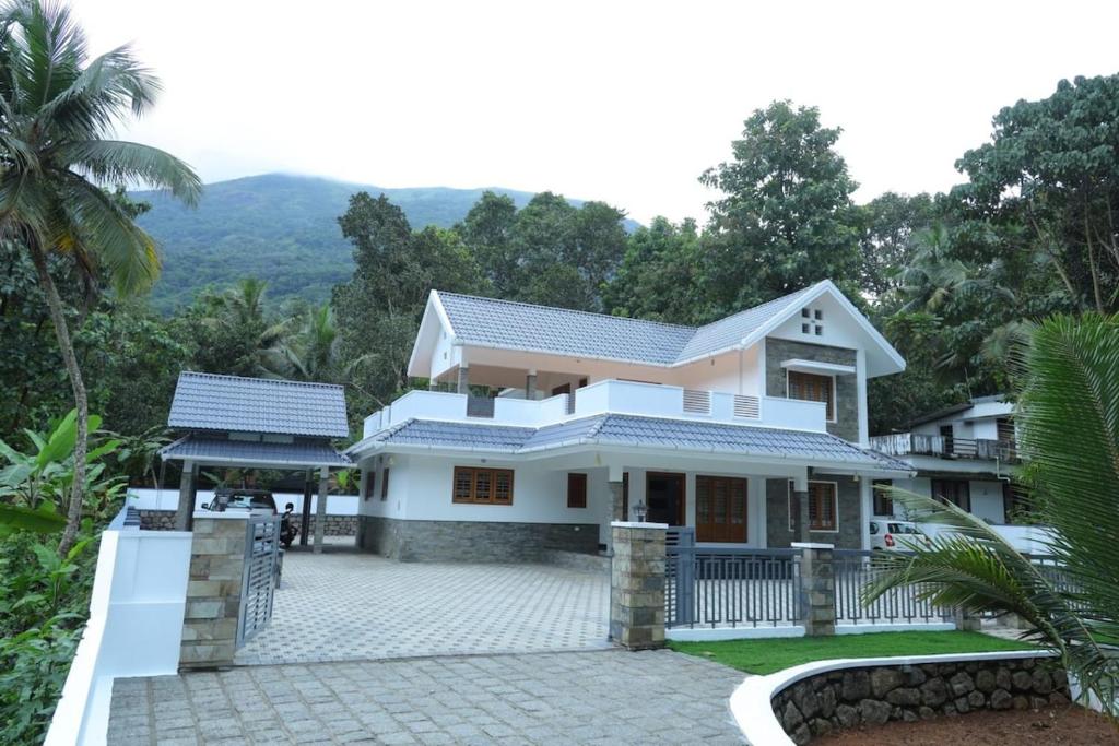 a house in the mountains with a driveway at Kanattu Homestay in Muttam