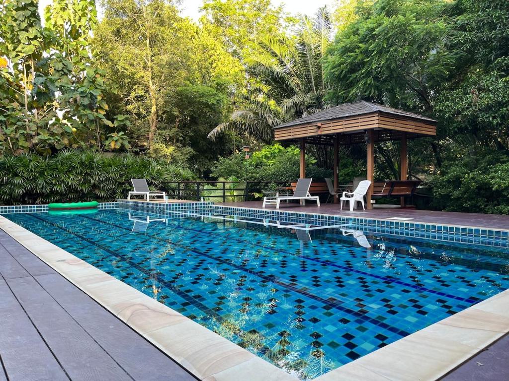 een zwembad met stoelen en een prieel bij The Wild Villa Phuket Rawai in Nai Harn Beach