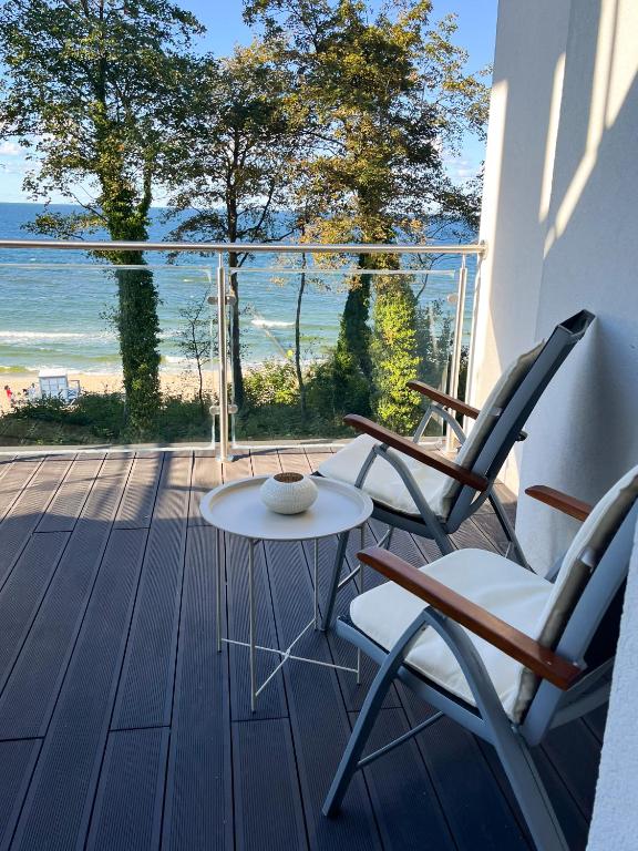 a patio with two chairs and a table and a view of the ocean at Baltic Crown - Premium Sea View Rewal in Rewal