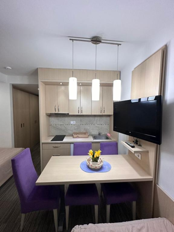 a kitchen with a dining table and purple chairs at Angela 103 in Kopaonik