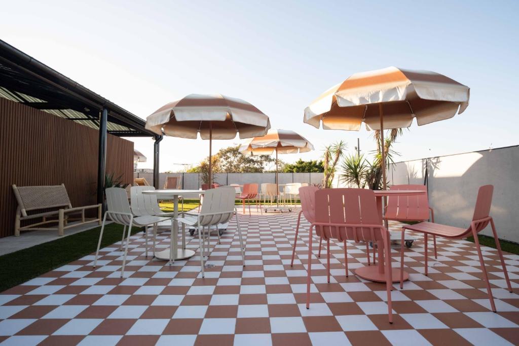 a patio with a table and chairs and umbrellas at Little Drifter Glebe in Sydney