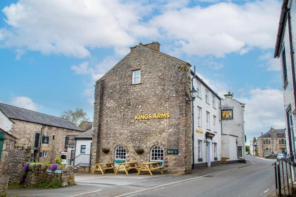 an old brick building with tables on a street at Kings Arms Hotel in Holme