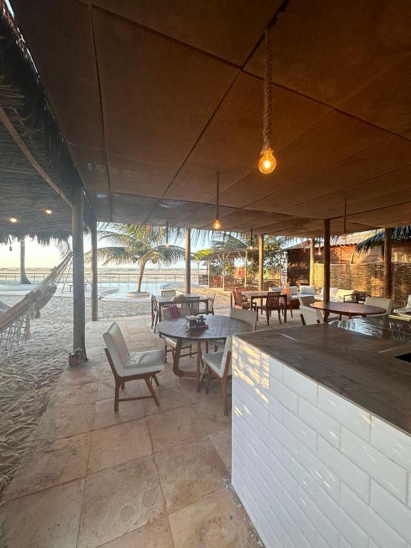 un patio esterno con tavoli e sedie e un bar di Villa kite a Itarema