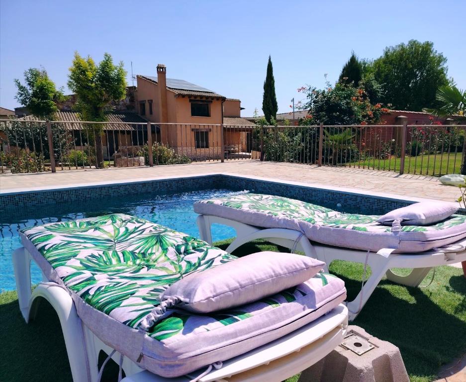 zwei Betten neben einem Swimmingpool in der Unterkunft La Casa del Corro in Villanueva de San Mancio