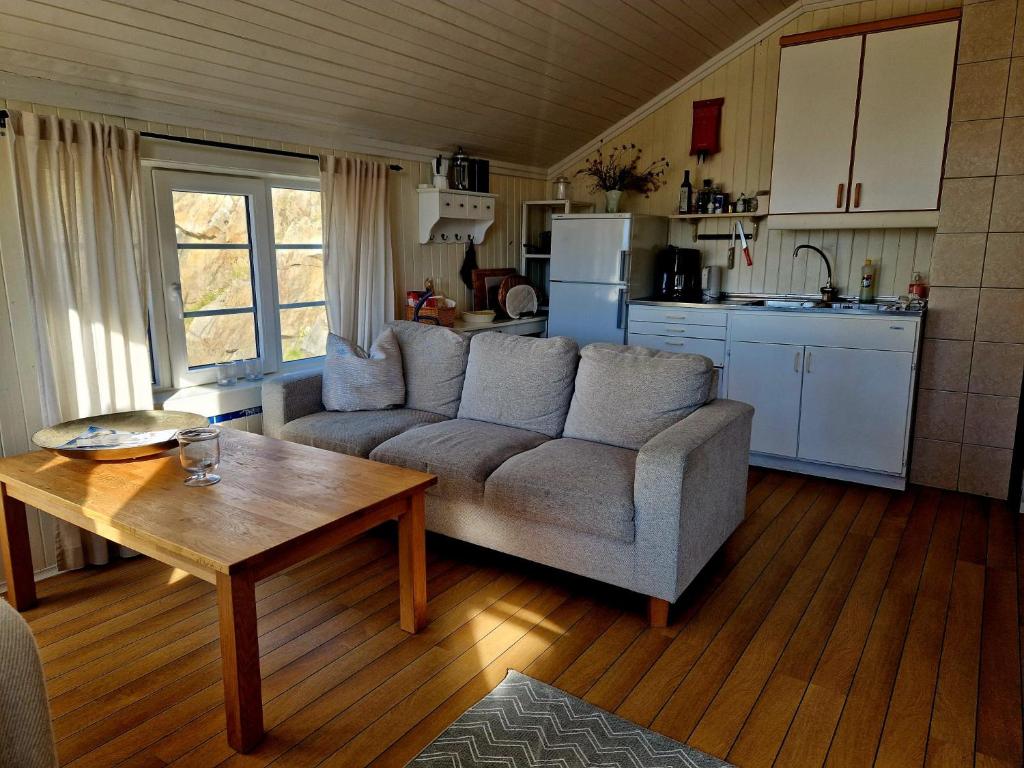 Una sala de estar con un sofá y una mesa y una cocina. en Arthur Brygga Nyksund, en Nyksund