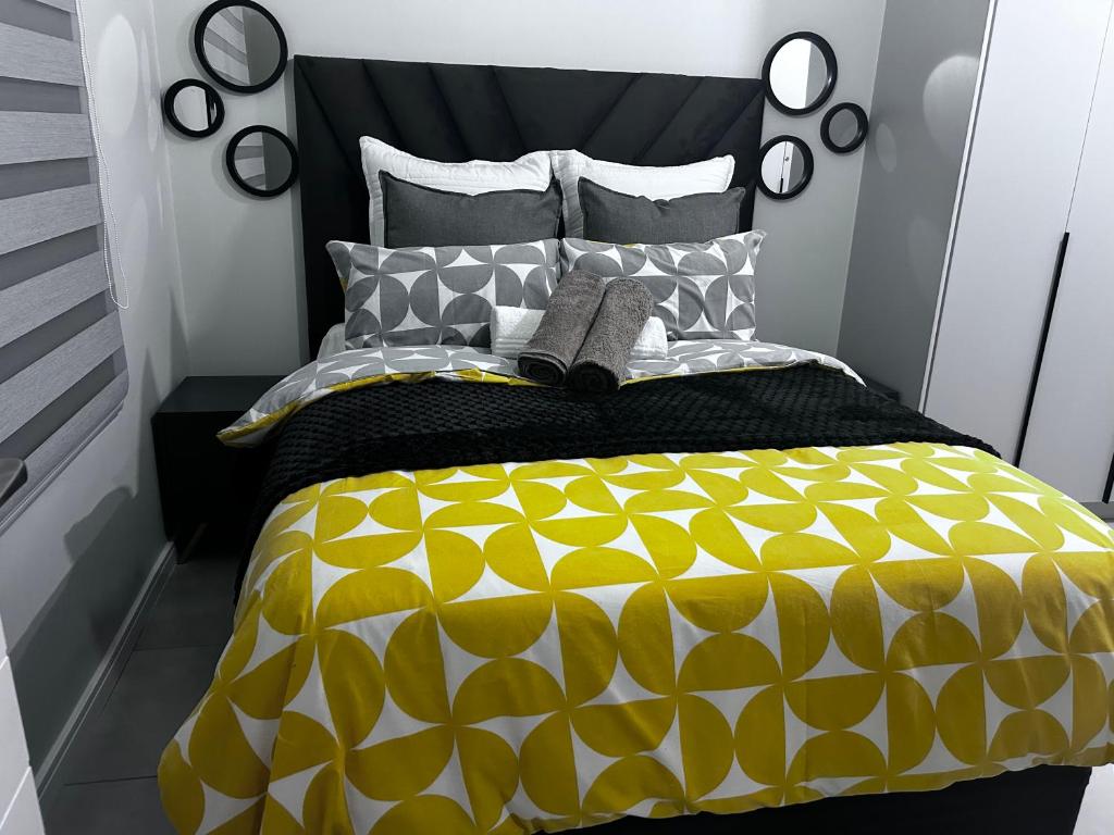 a bedroom with a bed with a yellow and black comforter at The Blyde blue lagoon in Pretoria