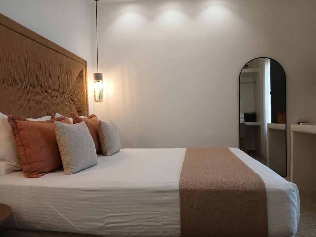 Un dormitorio con una cama grande con almohadas naranjas. en Anais Of Naxos, en Agia Anna de Naxos
